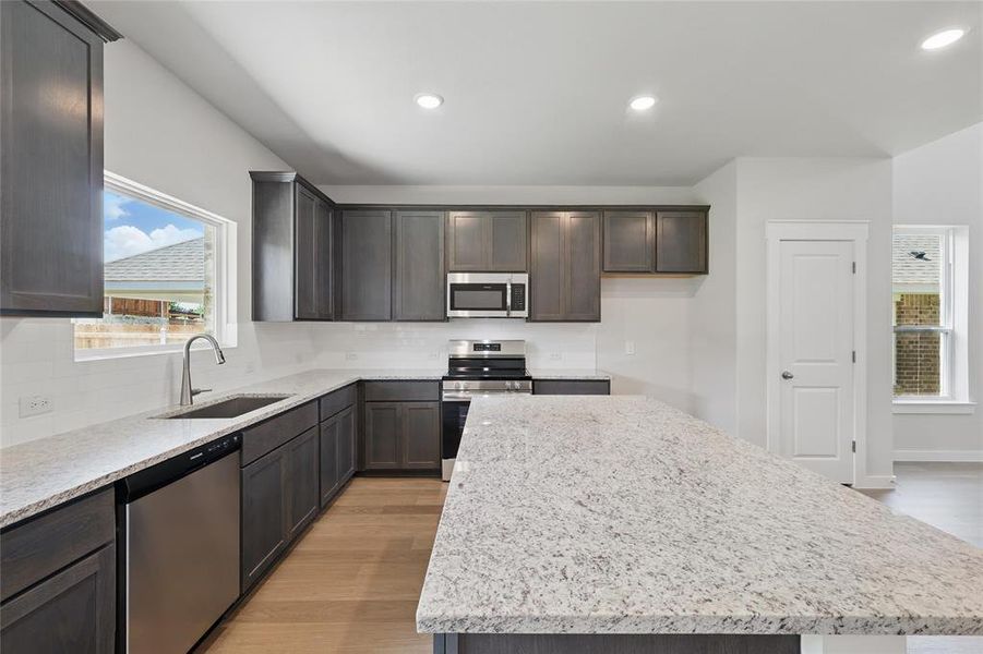 Kitchen with healthy amount of natural light, backsplash, stainless steel appliances, and recessed lighting