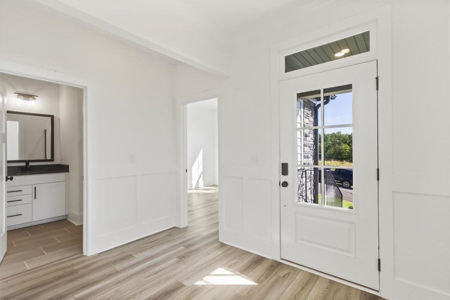 An inviting entryway presents elegant wainscoting