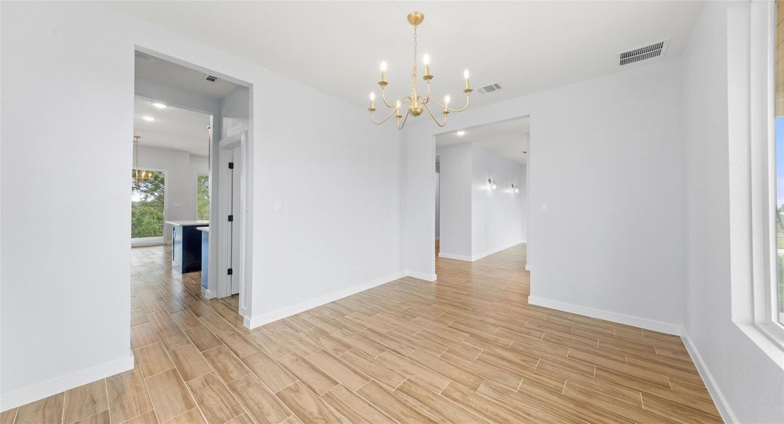 Spare room with a chandelier, wood tiled floors, and recessed lighting