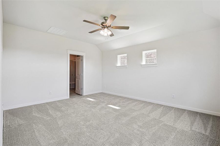 Empty room with ceiling fan, light carpet, and lofted ceiling