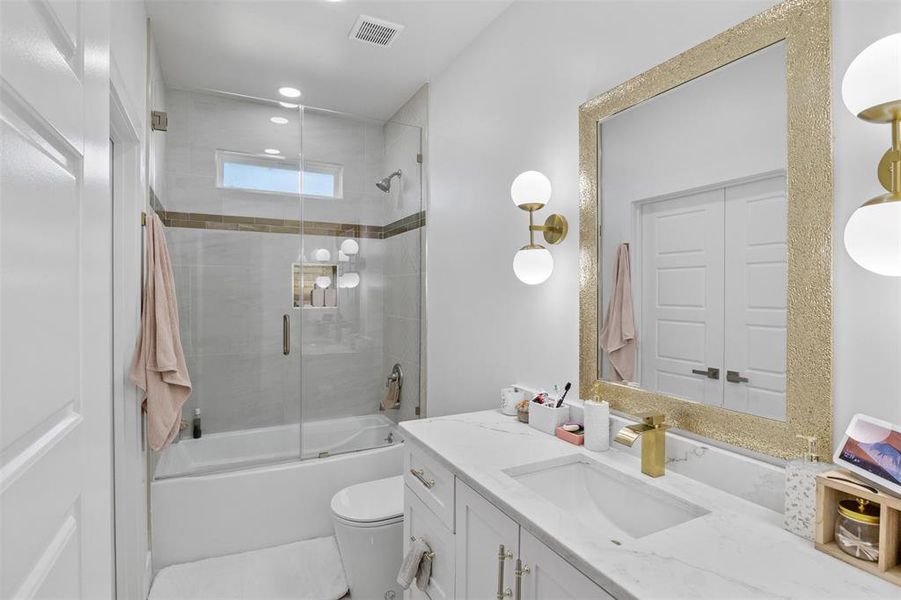 Full bathroom featuring combined bath / shower with glass door, vanity, and recessed lighting Full bathroom featuring combined bath / shower with glass door, vanity, and recessed lighting