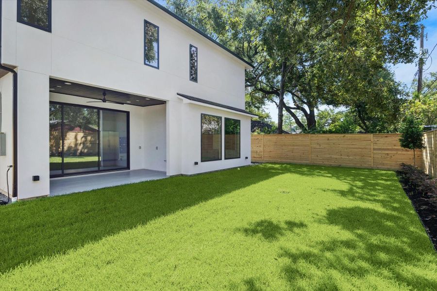 The covered patio expands the home’s living area, complete with recessed lighting, a ceiling fan, and ample room for outdoor dining and lounging. Large sliding glass doors open the interior to the outdoors, bringing in natural light and creating seamless flow to the private backyard.