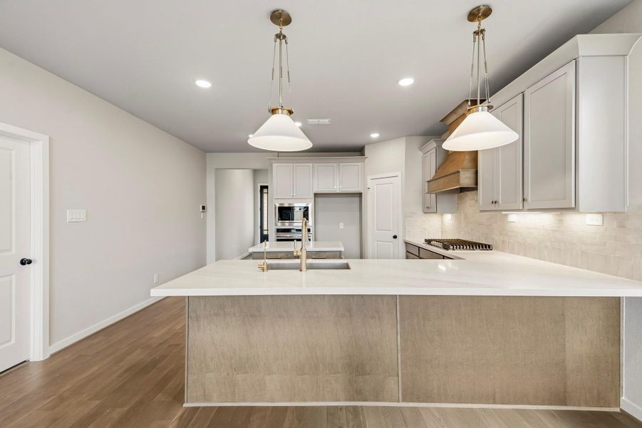 Charming gold pendants hang over the kitchen island, with room for at least 5 barstools! Charming gold pendants hang over the kitchen island, with room for at least 5 barstools!