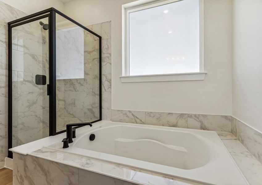 The master bathroom has a large walk-in, glass shower and garden tub.