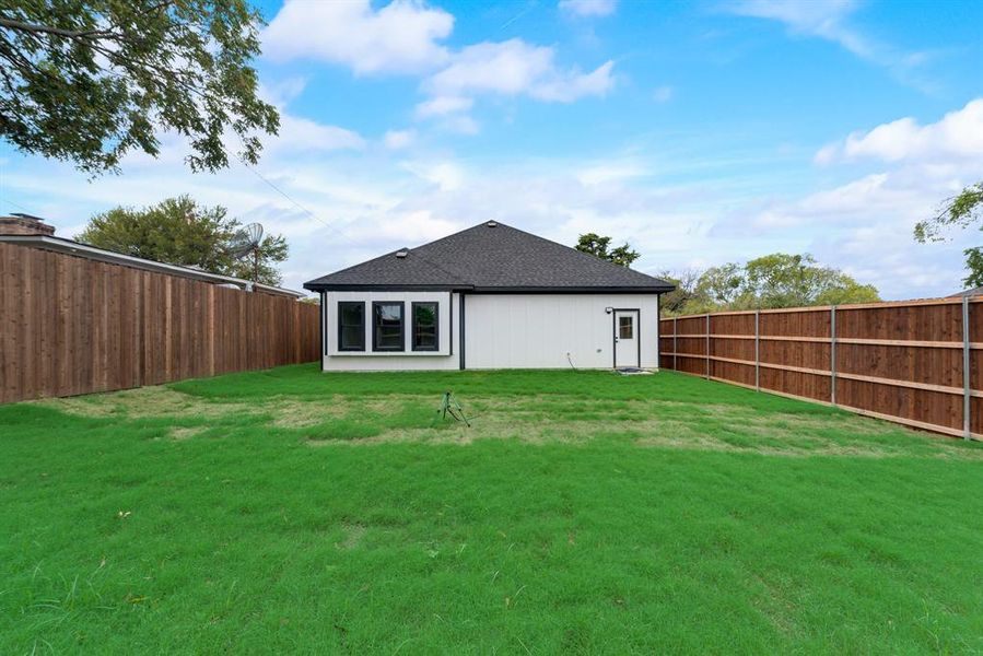 Rear view of property featuring a yard