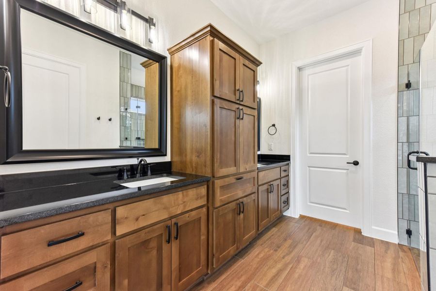 Full bath featuring vanity, light wood finished floors, and a stall shower