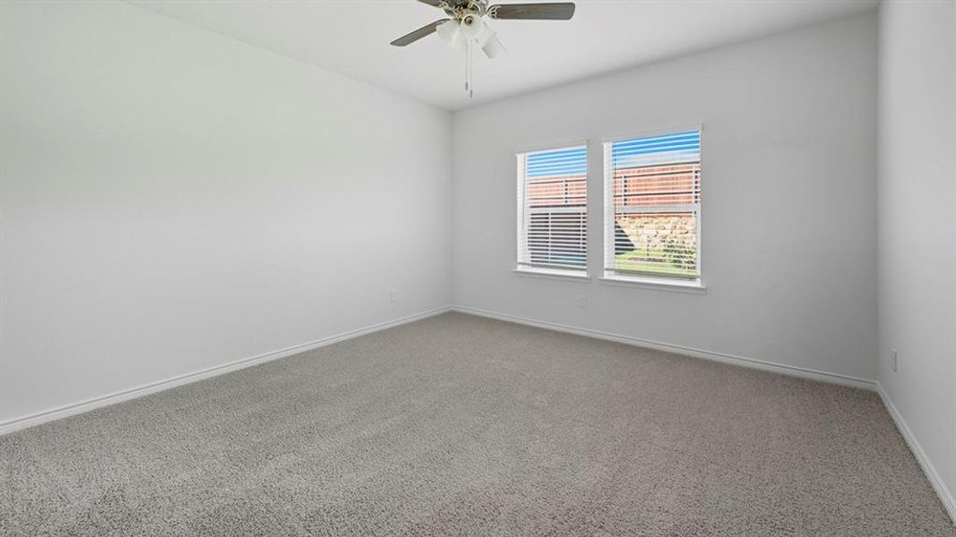 Empty room with carpet flooring and a ceiling fan