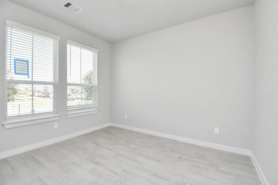 Quietly nestled in front of the home is the sophisticated home office. Featuring elegant tile, custom paint and large window. Sample photo of completed home with similar floor plan. Actual colors and selections may vary.