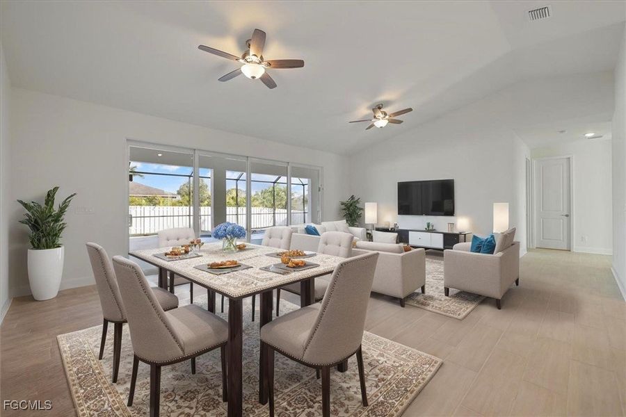 Dining area featuring vaulted ceiling, ceiling fan, and light wood-style flooring Dining area featuring vaulted ceiling, ceiling fan, and light wood-style flooring