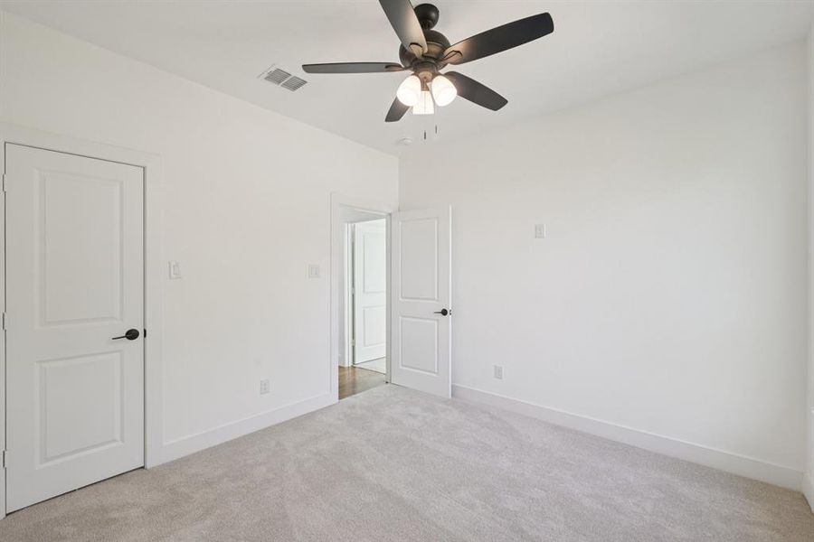 Unfurnished bedroom featuring light carpet and a ceiling fan