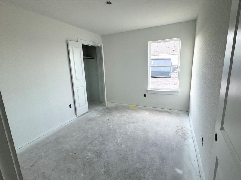 Unfurnished bedroom with baseboards and unfinished concrete floors