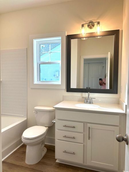Full bathroom featuring dark wood-style floors, vanity, and bathing tub / shower combination