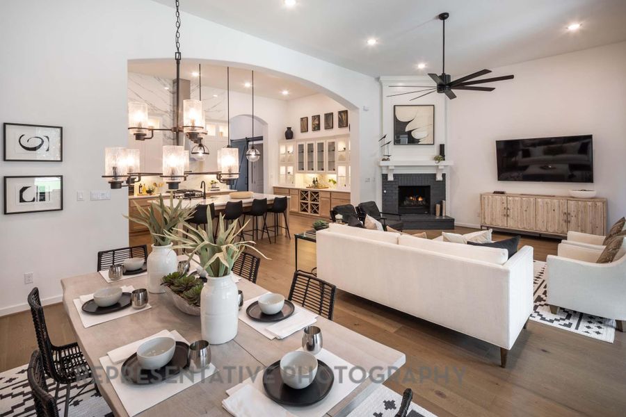 Living room with a ceiling fan, a chandelier, wood finished floors, arched walkways, and recessed lighting Living room with a ceiling fan, a chandelier, wood finished floors, arched walkways, and recessed lighting