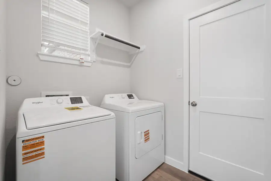 A washing machine and dryer in a room. A washing machine and dryer in a room.