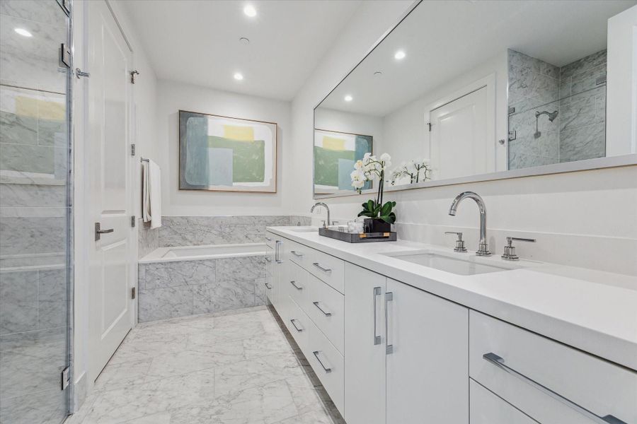 Primary bathroom with dual sinks, quartz counter-top, soaking tub, glass-framed walk-in shower, linen closet, private water-closet and a large walk-in dressing room. Photos are of a similar unit with the same floor plan