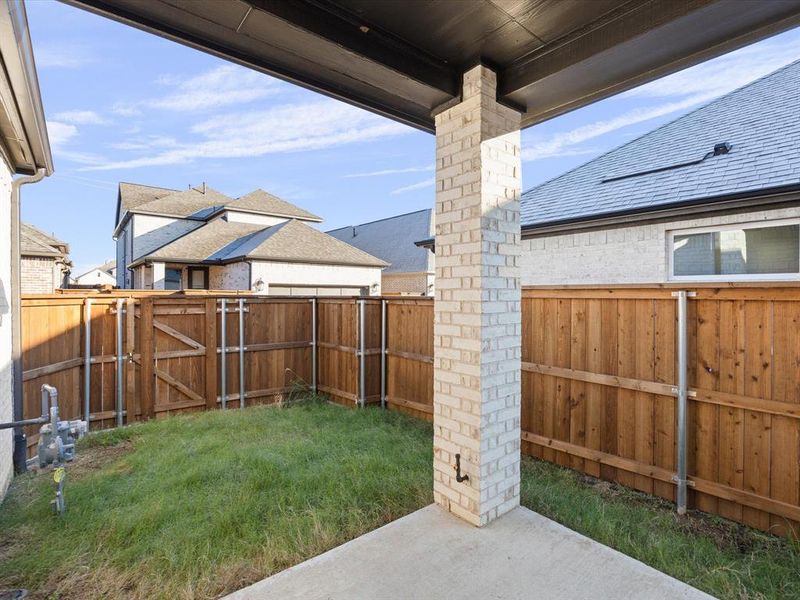 Fenced backyard featuring a patio and a gate Fenced backyard featuring a patio and a gate