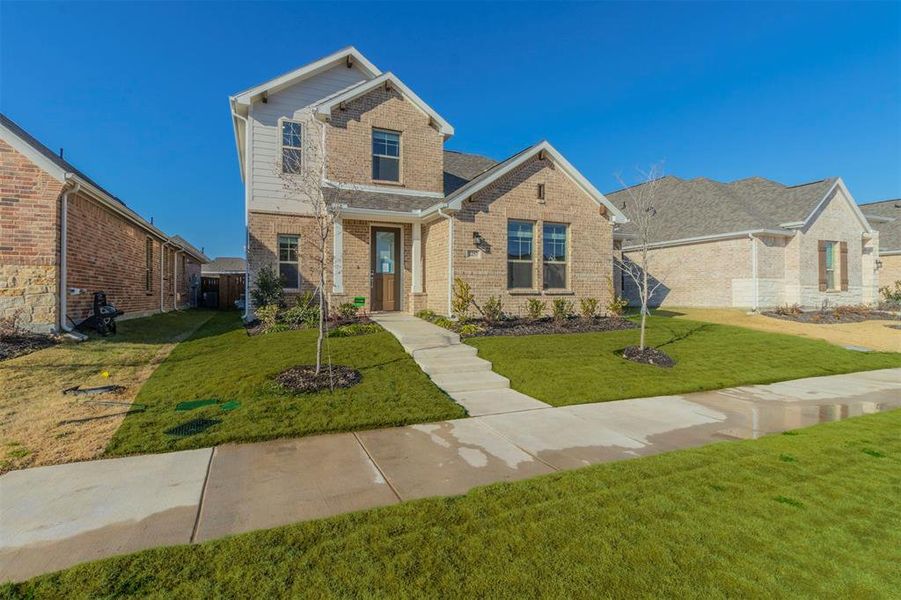 Traditional-style house with brick siding and a front yard