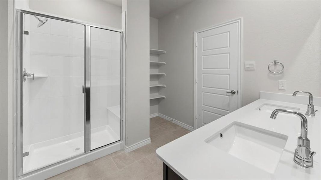 Modern bath featuring a glass-enclosed shower with white subway tile, a built-in shower bench, and dual undermount sinks set in a white countertop Modern bath featuring a glass-enclosed shower with white subway tile, a built-in shower bench, and dual undermount sinks set in a white countertop
