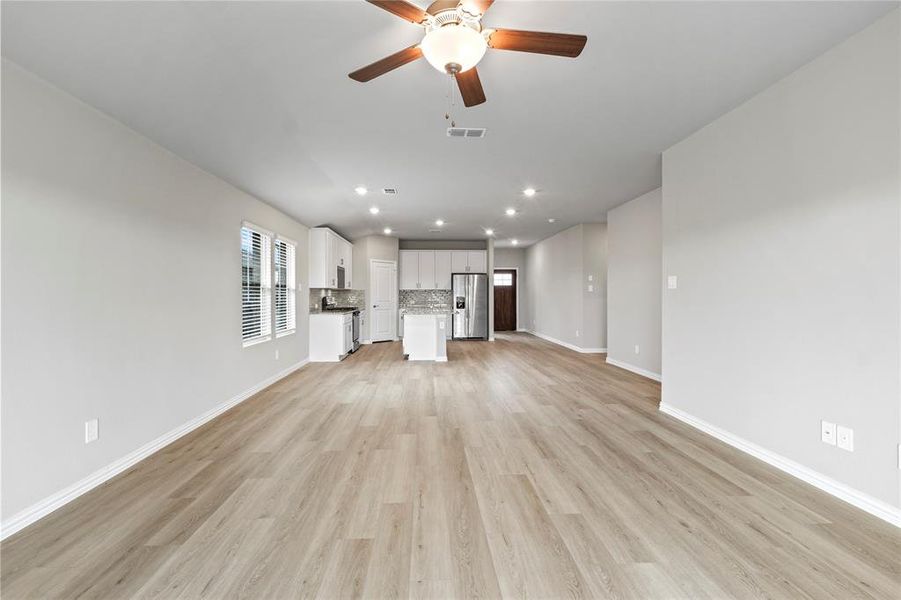 Unfurnished living room featuring ceiling fan, light wood-style floors, and recessed lighting Unfurnished living room featuring ceiling fan, light wood-style floors, and recessed lighting
