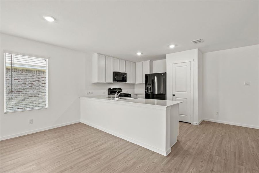 Open-concept living area featuring wood-finish flooring and recessed lighting