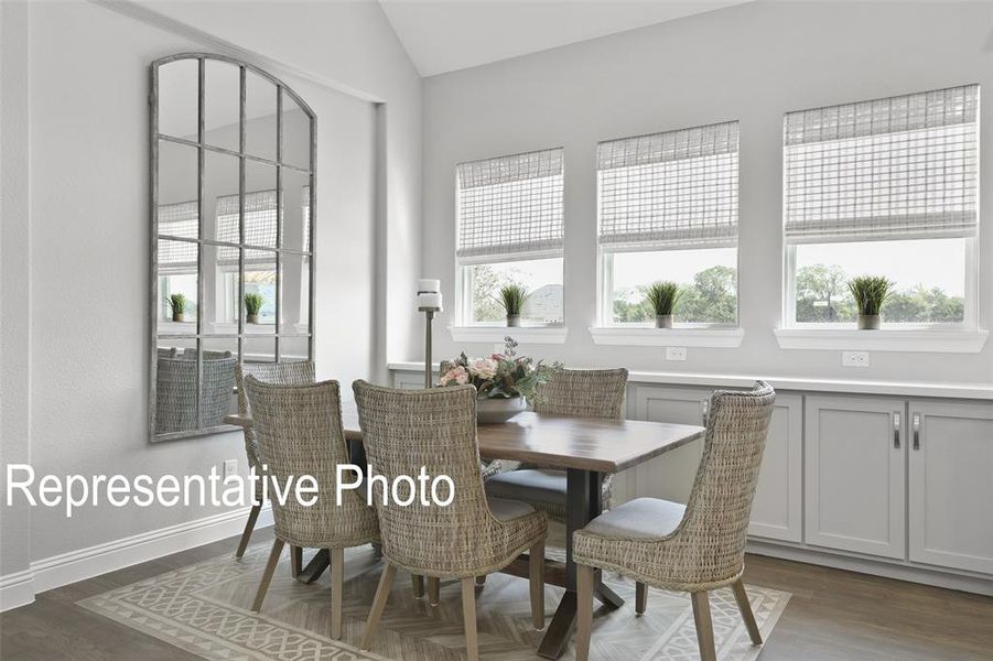 Dining room with vaulted ceiling and dark hardwood / wood-style floors