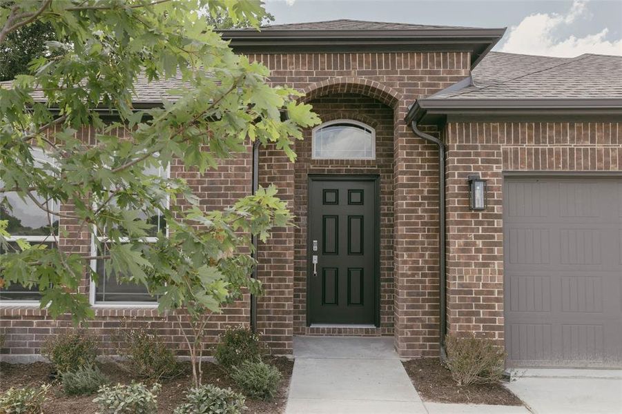 View of exterior entry with a garage