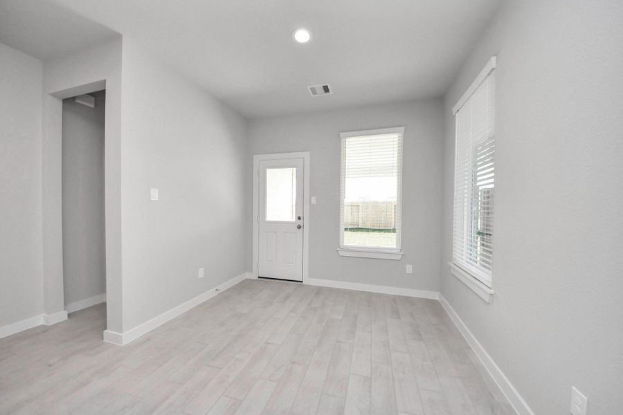 Enjoy breakfast with ease in the connected and cozy breakfast area, seamlessly integrated with the kitchen for utmost convenience. Step through the back door for a breath of fresh air onto the covered patio, extending your living space to the outdoors. Sample photo of completed home with similar floor plan. Actual colors and selections may vary.