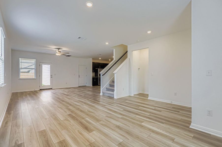 Unfurnished living room featuring recessed lighting, stairs, light wood finished floors, and a ceiling fan Unfurnished living room featuring recessed lighting, stairs, light wood finished floors, and a ceiling fan