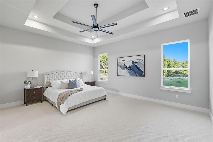 Bedroom featuring carpet flooring, a tray ceiling, a ceiling fan, and recessed lighting Bedroom featuring carpet flooring, a tray ceiling, a ceiling fan, and recessed lighting