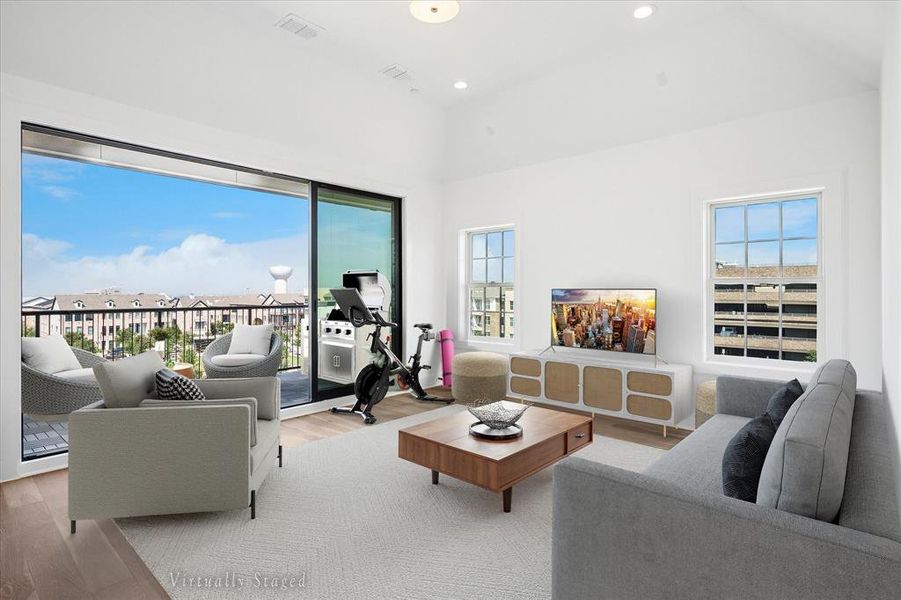 Spacious living area featuring a vaulted ceiling and wood-finish flooring