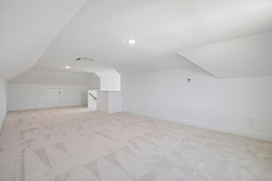 Angled ceilings and soft carpeting define this versatile upper-level bonus space.