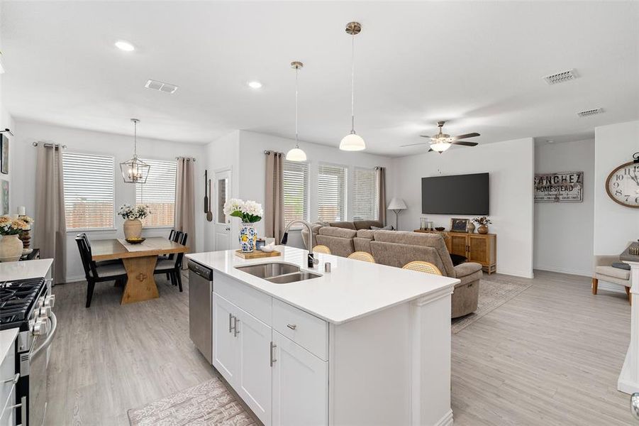 The property features an open-concept living area with light wood-style flooring throughout