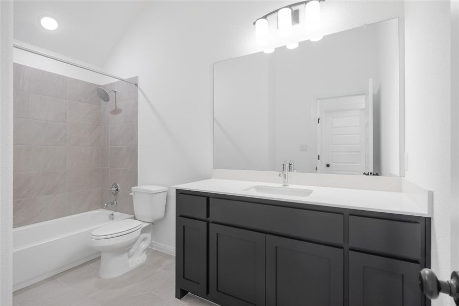 Bathroom with bathtub / shower combination, vanity, and light tile patterned floors