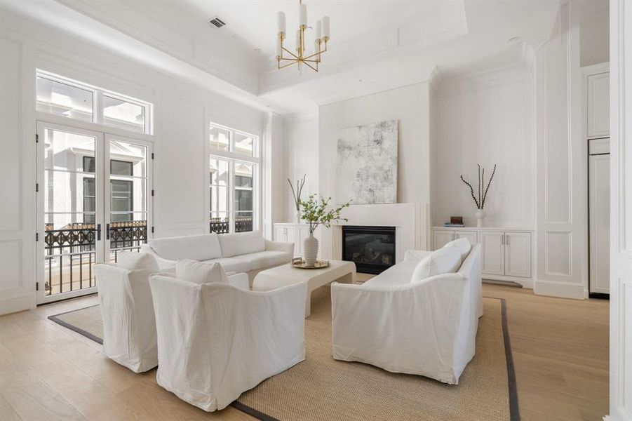 The whole of the expansive living area is lined large windows as well as a set of French doors which open to the Juliet balcony featuring intricate iron detailing. (photo of interior model home with smaller floor plan)