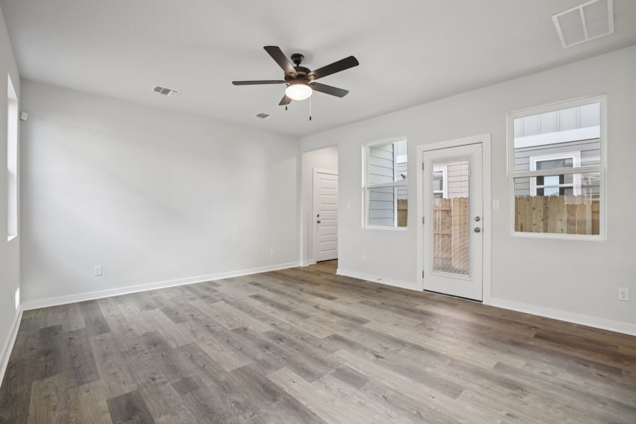 A room with a ceiling fan and a wood floor.