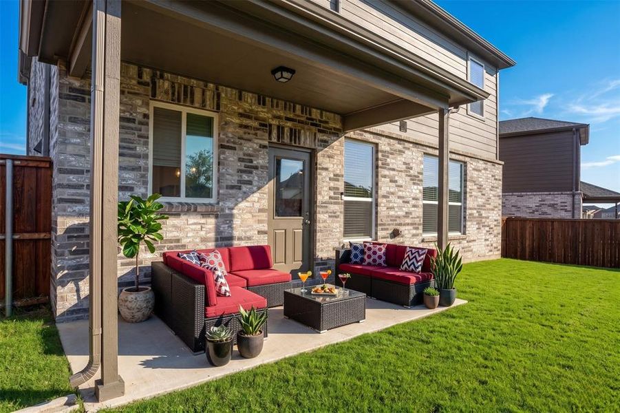 Covered concrete patio with a brick and siding exterior