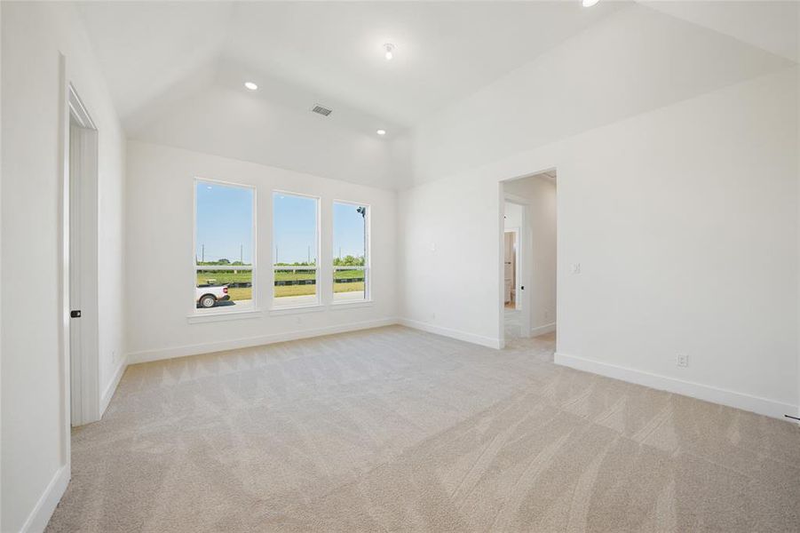 Spare room featuring light colored carpet, recessed lighting, and vaulted ceiling