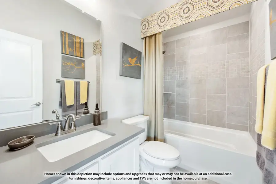 Bathroom with gray tile tub surround, white vanity with gray countertop, and decorative yellow accents Bathroom with gray tile tub surround, white vanity with gray countertop, and decorative yellow accents