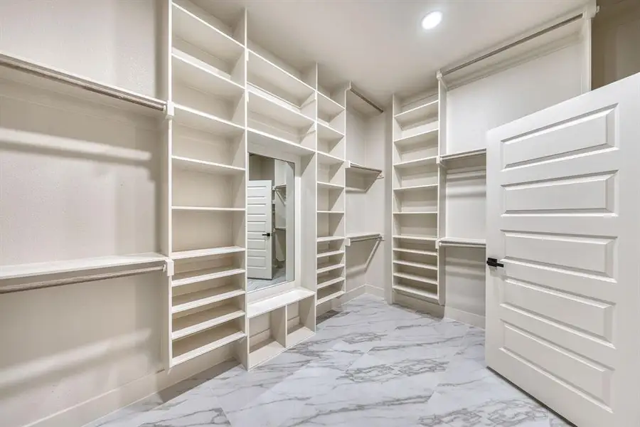 Walk in closet with light marble finish floors