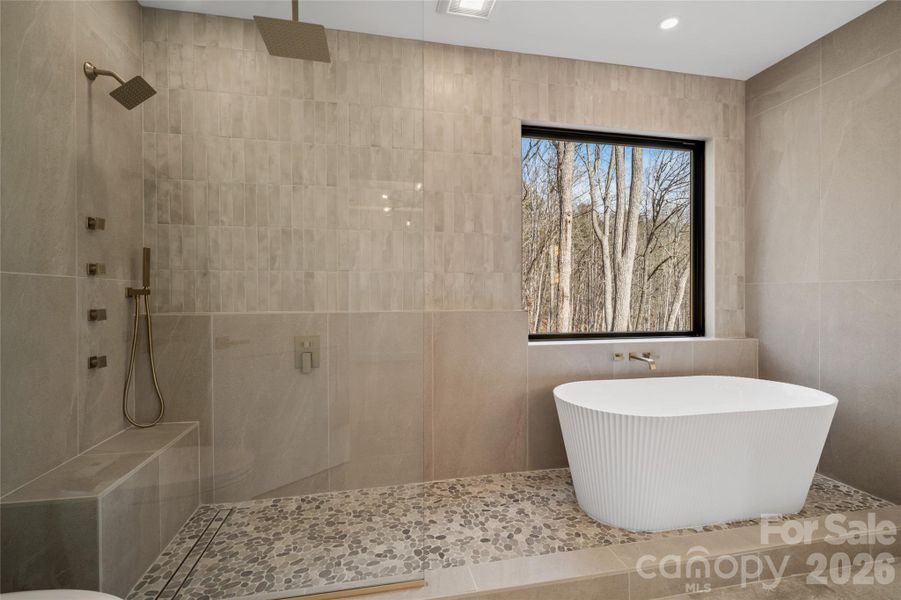 Spa inspired tile design with a seven-head shower system and a fluted soaking tub