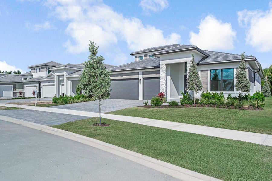 Front exterior of a new home in Esprit at Avenir, Palm Beach Gardens, FL, highlighting curb appeal (Image 2). Front exterior of a new home in Esprit at Avenir, Palm Beach Gardens, FL, highlighting curb appeal (Image 2).