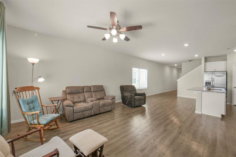 Spacious open-concept living area with Luxury Vinyl flooring, ceiling fan, and natural light. Ideal for comfortable living and entertaining. Spacious open-concept living area with Luxury Vinyl flooring, ceiling fan, and natural light. Ideal for comfortable living and entertaining.