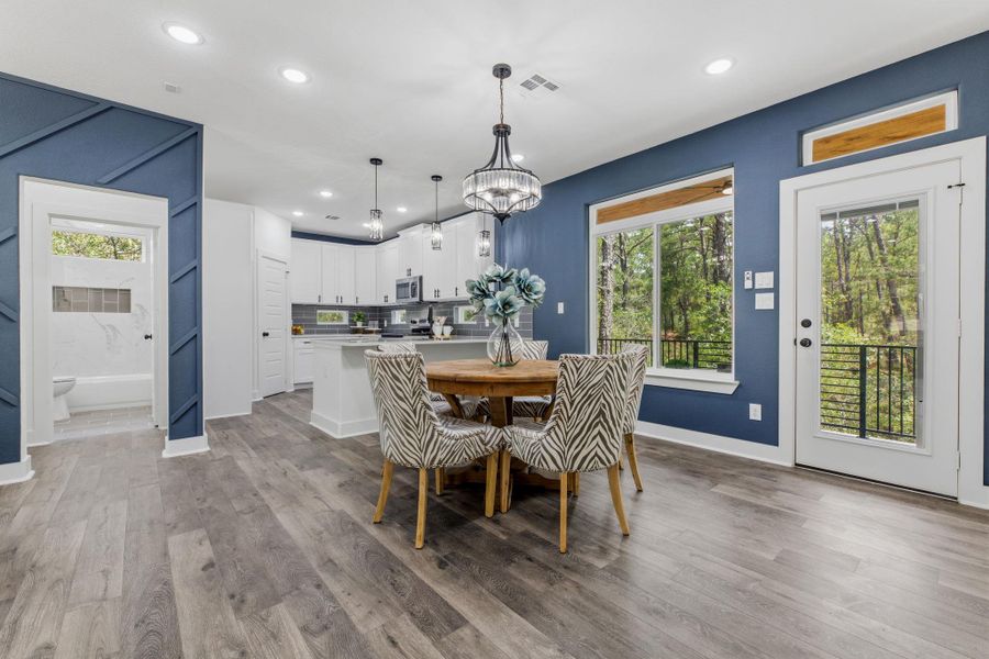 An open-concept living space connects a gourmet kitchen to a dining area with scenic outdoor views.