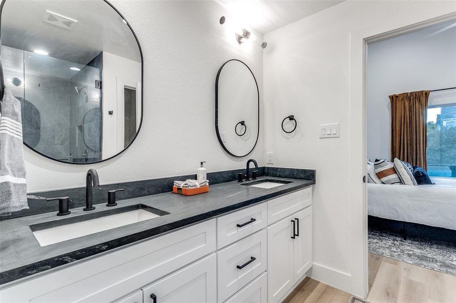 Bathroom with vanity, wood-type flooring, and an enclosed shower