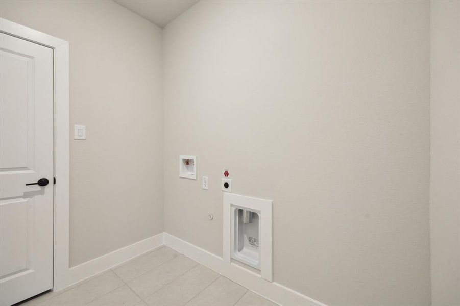 Washroom featuring electric dryer hookup, gas dryer hookup, hookup for a washing machine, and light tile patterned floors