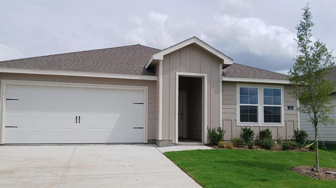 Contemporary single-story residence featuring a two-car garage, beige siding with vertical accents, and a covered entry Contemporary single-story residence featuring a two-car garage, beige siding with vertical accents, and a covered entry