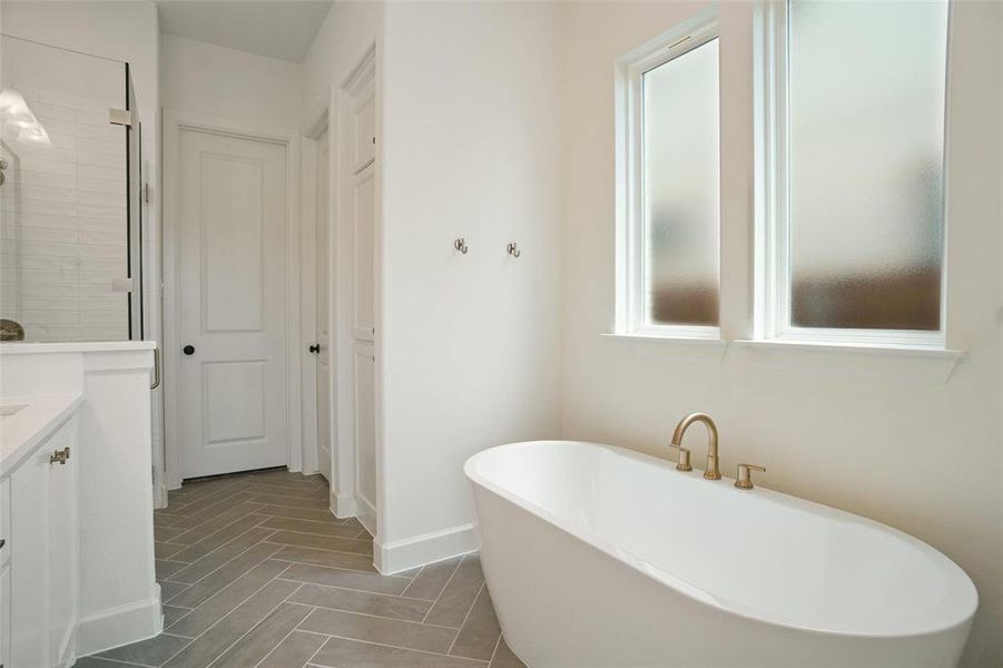 Bathroom featuring a soaking tub and vanity Bathroom featuring a soaking tub and vanity