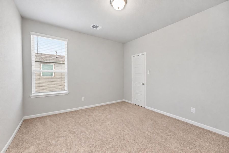 Secondary Bedroom is well-sized with a large window and flexible space for family, guests, or everyday use.