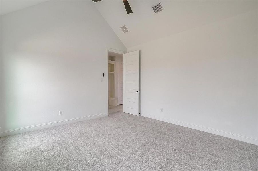 Unfurnished room with high vaulted ceiling, light colored carpet, and ceiling fan