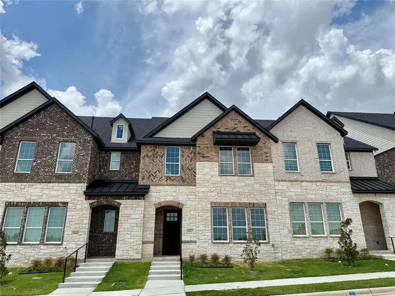 Front exterior of a new home in Aspen Square Townhomes, Irving, TX, highlighting curb appeal (Image 1).